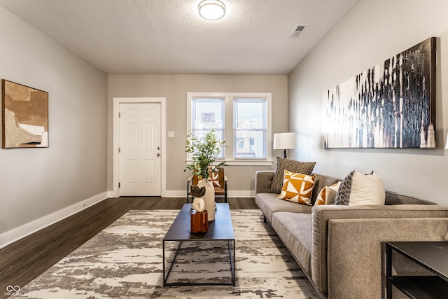 living room with wood-type flooring and a textured ceiling