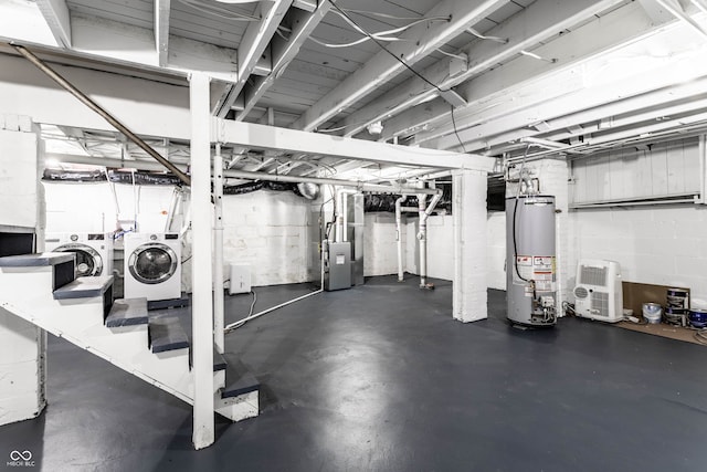 basement featuring washing machine and dryer, water heater, and heating unit