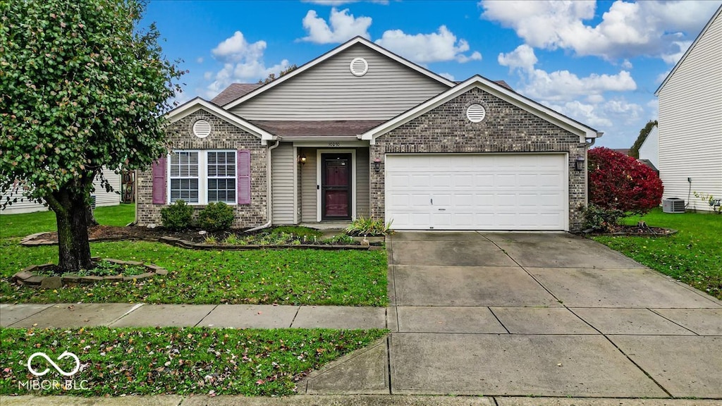 view of front of house featuring a front yard, a garage, and cooling unit