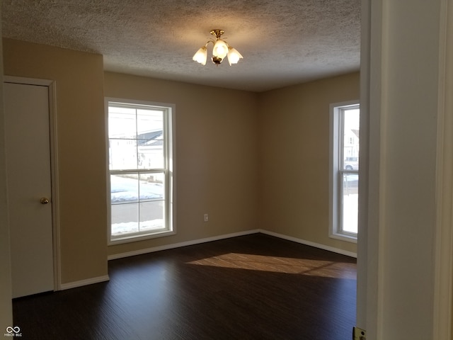 unfurnished room with dark wood-type flooring and a textured ceiling