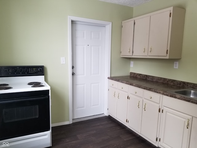 kitchen featuring white electric range oven, a textured ceiling, dark wood-type flooring, sink, and white cabinetry