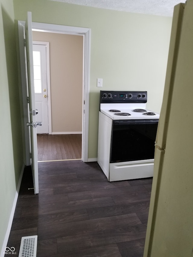 kitchen featuring a textured ceiling, white appliances, and dark wood-type flooring