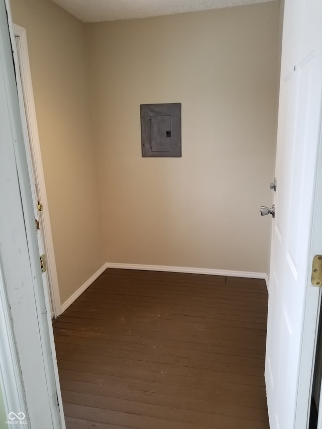 spare room featuring a textured ceiling, dark hardwood / wood-style flooring, and electric panel