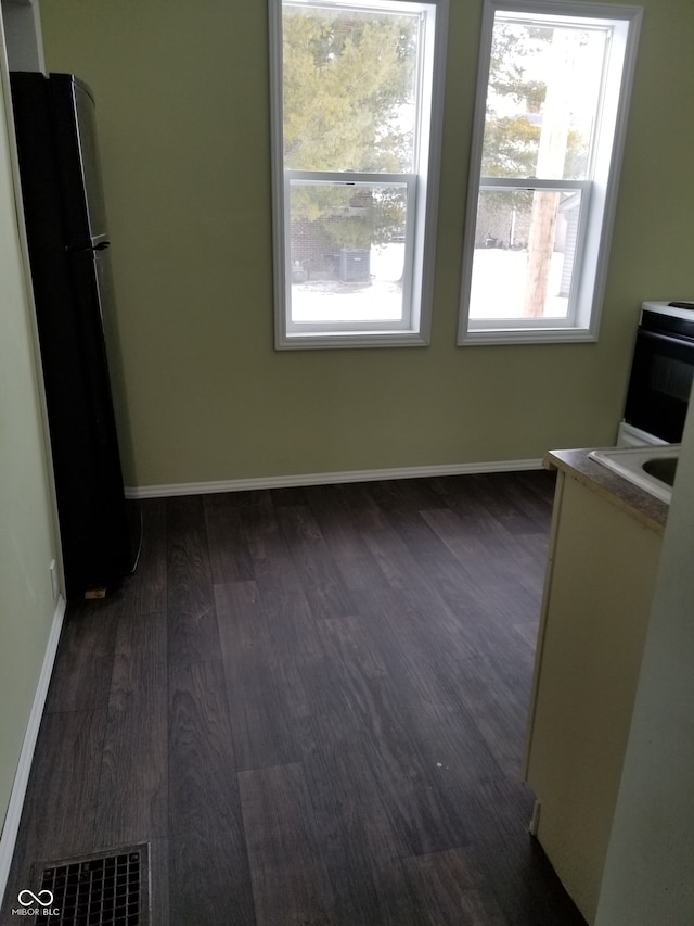 unfurnished dining area featuring dark hardwood / wood-style flooring