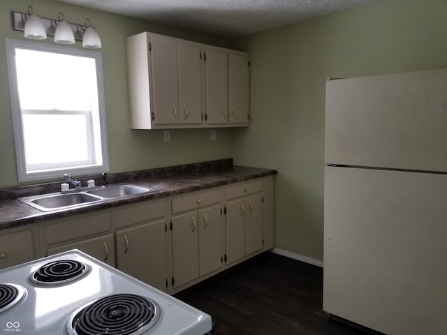 kitchen with white cabinetry, sink, dark hardwood / wood-style flooring, a textured ceiling, and white appliances