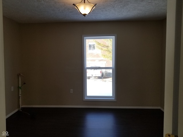 empty room featuring a textured ceiling and hardwood / wood-style flooring