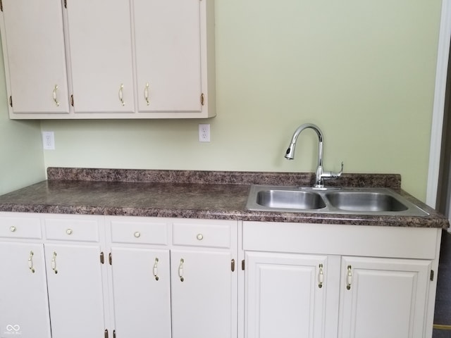 kitchen featuring white cabinetry and sink