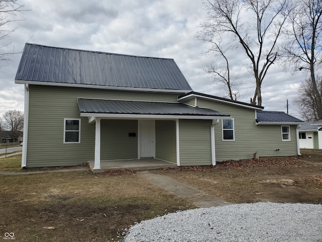 rear view of property featuring covered porch