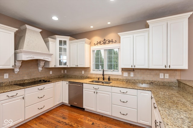 kitchen featuring white cabinets, dishwasher, custom range hood, black electric cooktop, and a sink