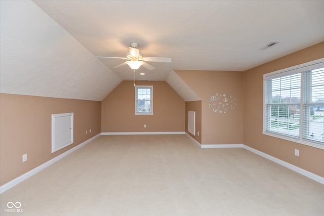 bonus room featuring light carpet, baseboards, visible vents, ceiling fan, and vaulted ceiling