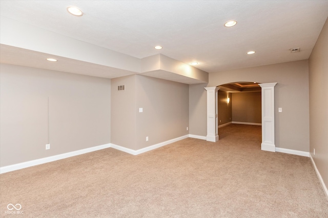 below grade area featuring light carpet, baseboards, arched walkways, and recessed lighting