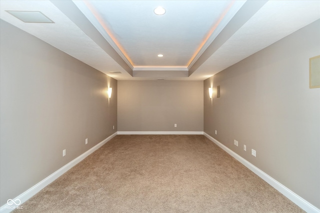 carpeted spare room with baseboards, a raised ceiling, and recessed lighting