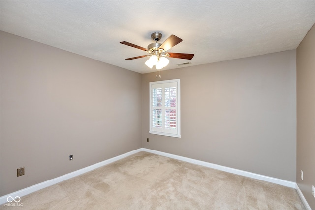 unfurnished room with visible vents, light carpet, ceiling fan, a textured ceiling, and baseboards