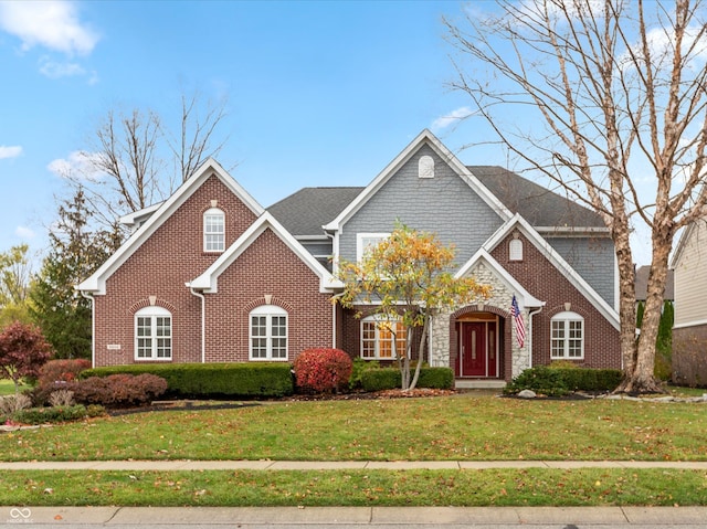 traditional-style house featuring stone siding, brick siding, and a front yard