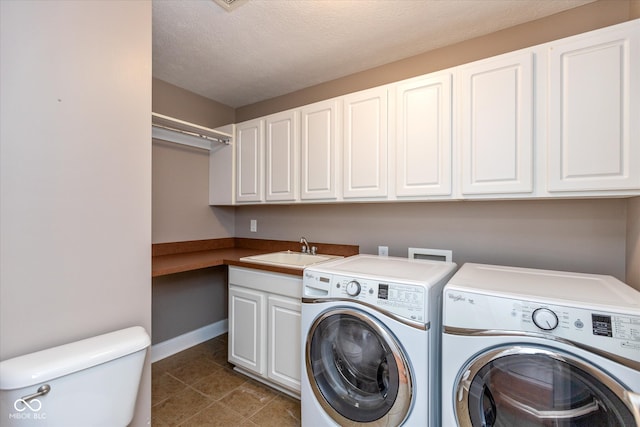 laundry area with laundry area, tile patterned floors, independent washer and dryer, a textured ceiling, and a sink