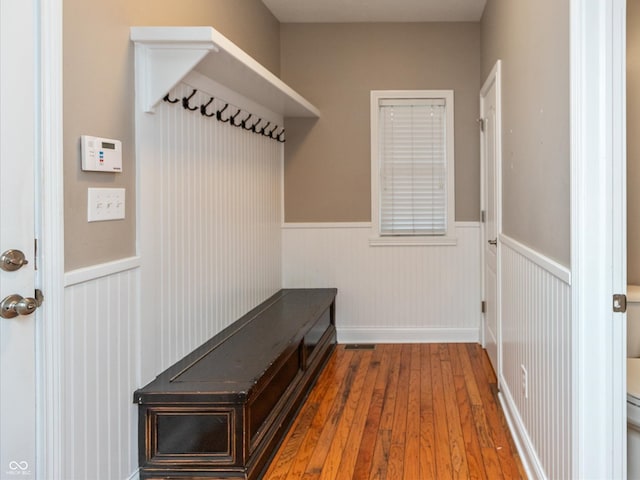 mudroom with wood-type flooring and a wainscoted wall