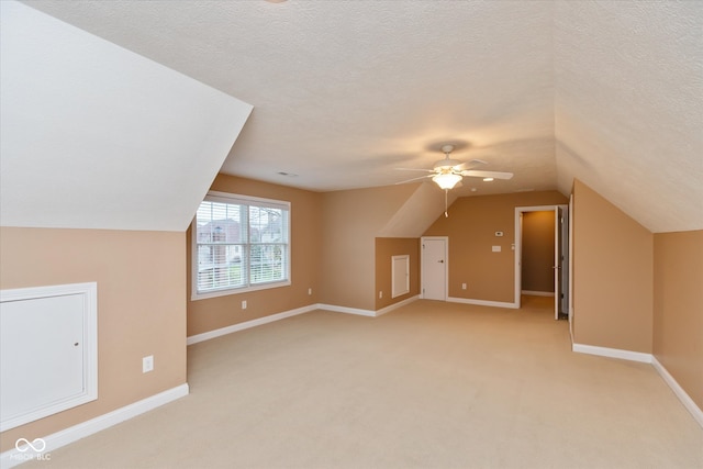 bonus room with light carpet, baseboards, vaulted ceiling, and a textured ceiling