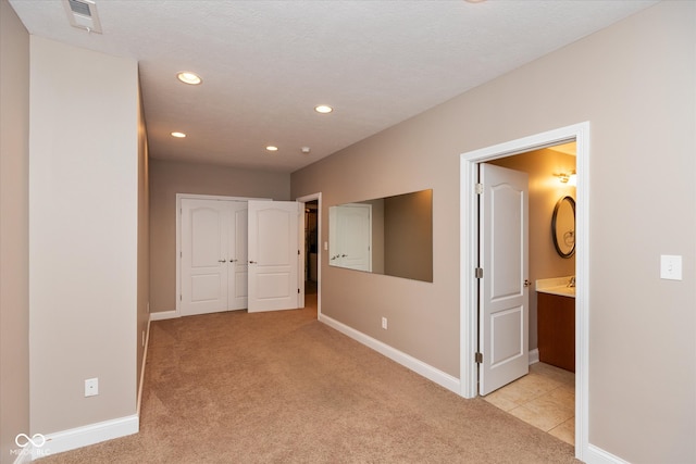 unfurnished bedroom with light carpet, baseboards, visible vents, and recessed lighting