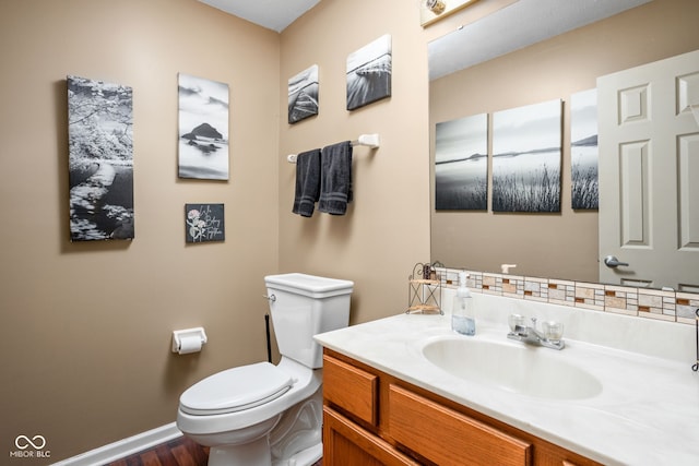 bathroom with wood-type flooring, vanity, and toilet