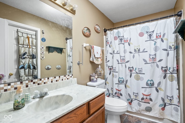 bathroom featuring curtained shower, vanity, a textured ceiling, and toilet