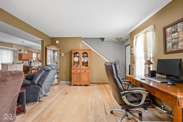 office area with light hardwood / wood-style flooring and a chandelier