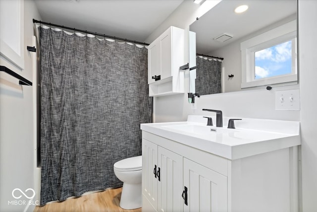 bathroom with a shower with shower curtain, vanity, toilet, and wood-type flooring