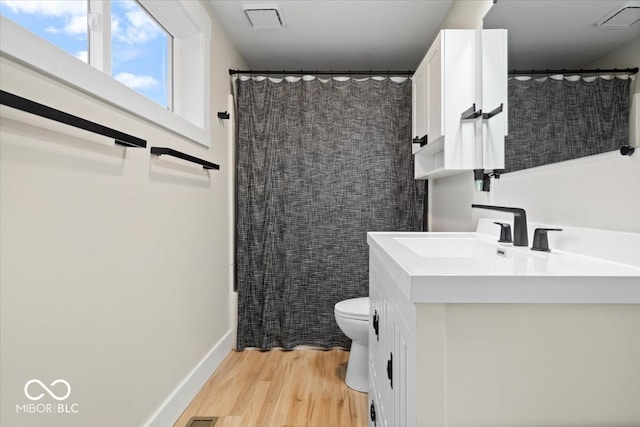 bathroom with curtained shower, toilet, vanity, and hardwood / wood-style flooring