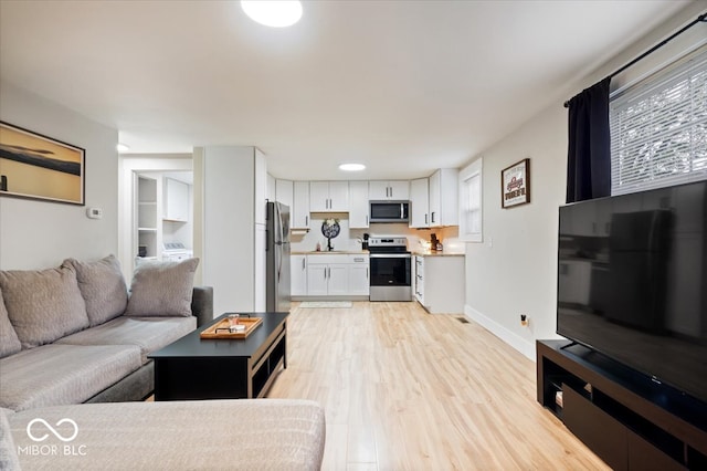 living room featuring sink and light wood-type flooring