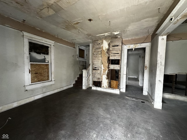 1210 N Rural St, Indianapolis, IN 46201 - unfurnished living room featuring unfinished concrete flooring and stairway