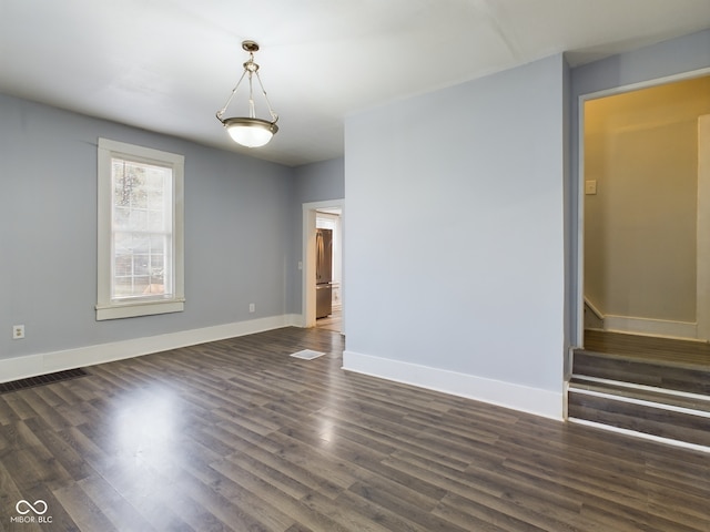 spare room featuring dark wood-type flooring