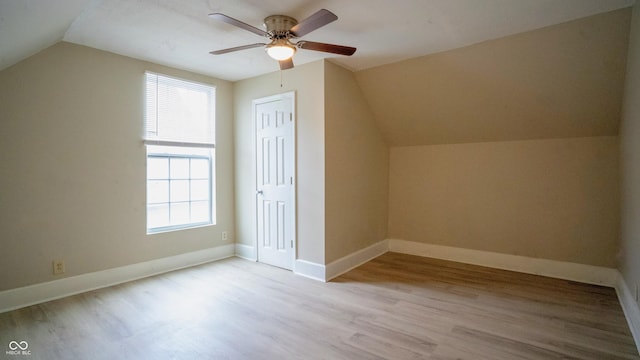 additional living space featuring lofted ceiling, ceiling fan, baseboards, and wood finished floors