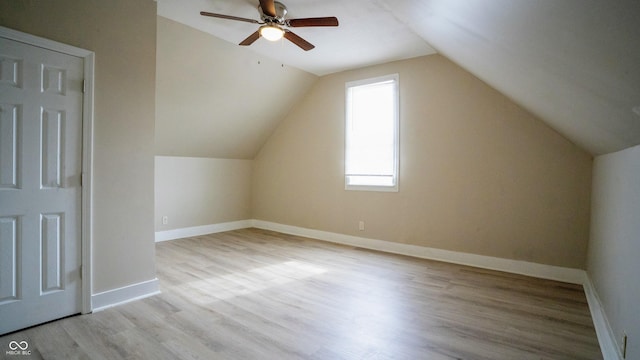 bonus room with ceiling fan, vaulted ceiling, baseboards, and wood finished floors