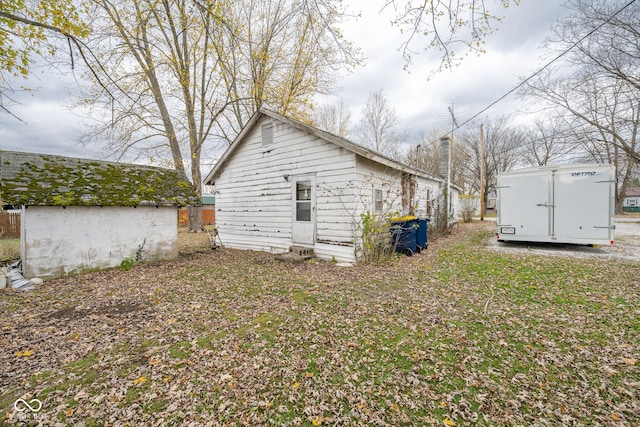 rear view of property featuring an outbuilding