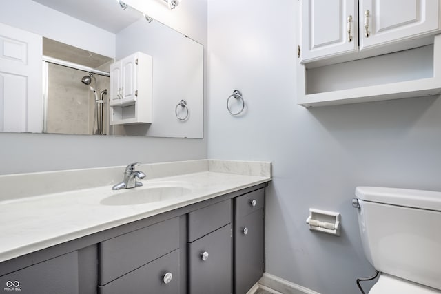 bathroom with vanity, toilet, and a tile shower