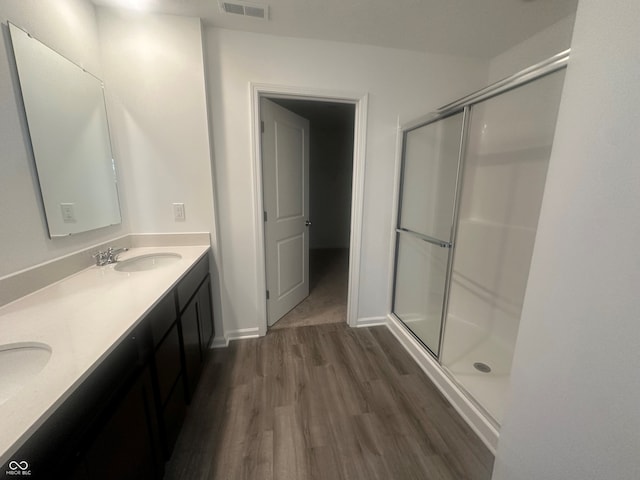 bathroom with wood-type flooring, vanity, and walk in shower