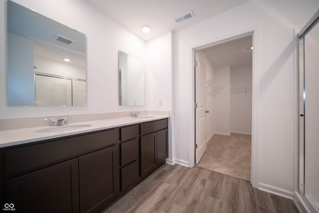 7904 Magnolia St, New Palestine, IN 46163 - full bath with wood finished floors, a walk in closet, a stall shower, double vanity, and baseboards