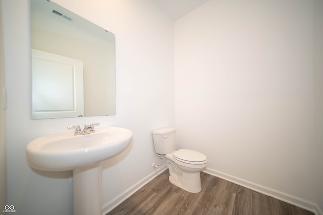 7904 Magnolia St, New Palestine, IN 46163 - bathroom with wood finished floors, toilet, baseboards, and a sink