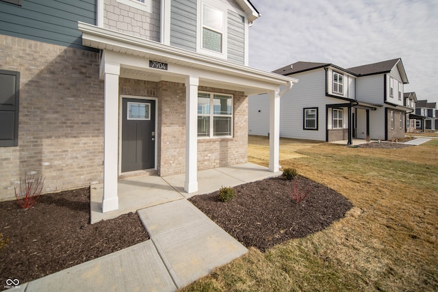 7904 Magnolia St, New Palestine, IN 46163 - view of exterior entry with brick siding and a lawn
