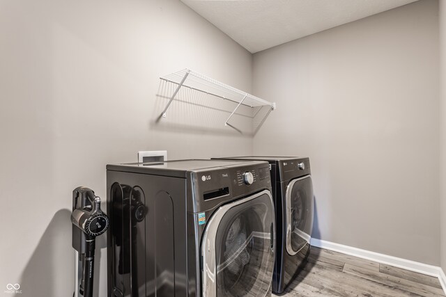 laundry room with washer and dryer and light hardwood / wood-style flooring