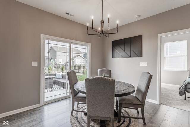 dining space with wood-type flooring and a notable chandelier