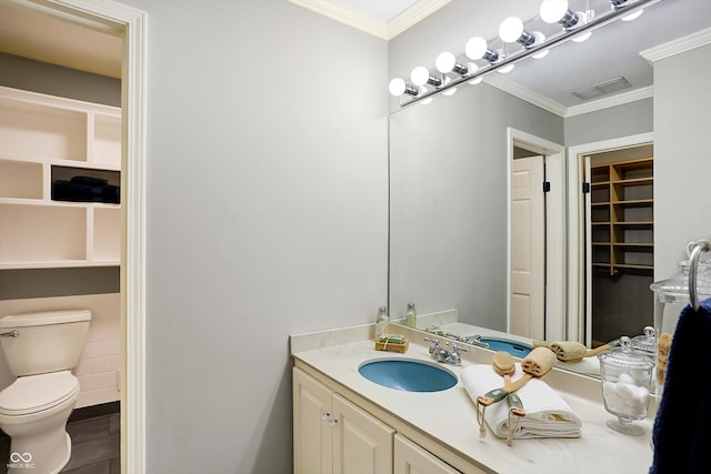 bathroom with vanity, ornamental molding, and toilet