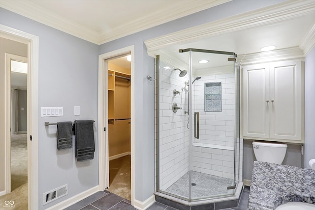 bathroom with vanity, a shower with door, crown molding, tile patterned flooring, and toilet