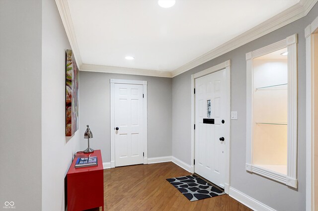 entrance foyer with dark hardwood / wood-style floors and crown molding