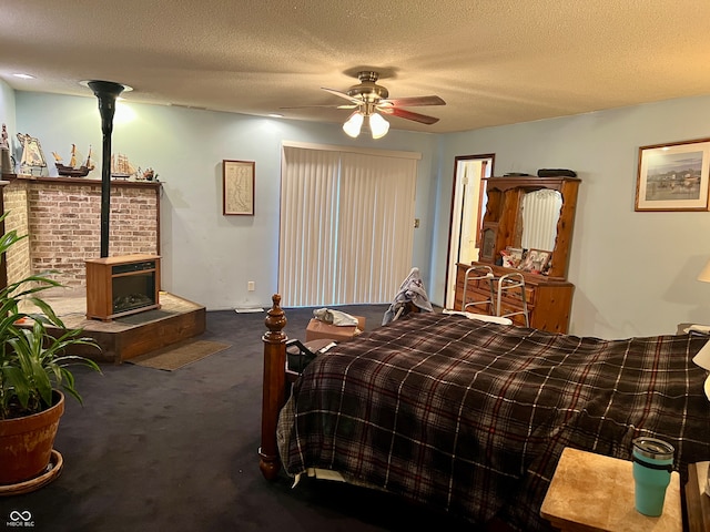 bedroom with a textured ceiling, carpet floors, a wood stove, and ceiling fan