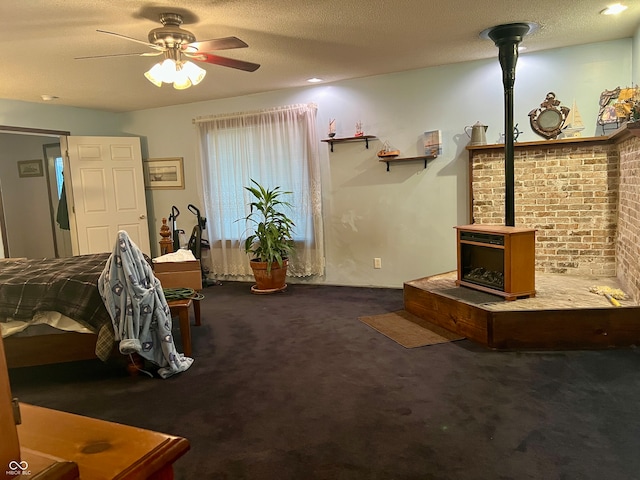 interior space featuring ceiling fan, a wood stove, and a textured ceiling