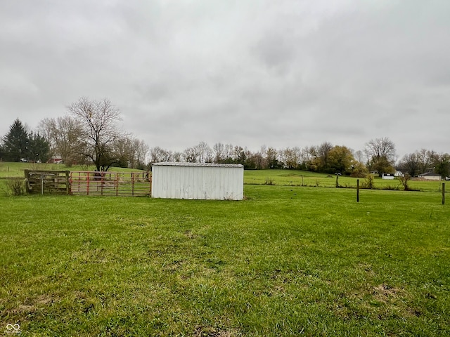 view of yard with a rural view and an outdoor structure