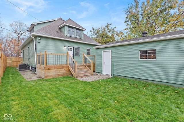 back of house with central AC, a deck, and a lawn