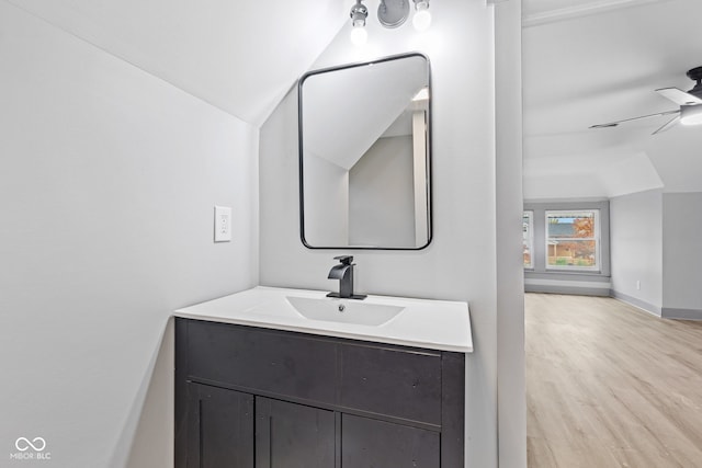 bathroom with vanity, ceiling fan, wood-type flooring, and vaulted ceiling