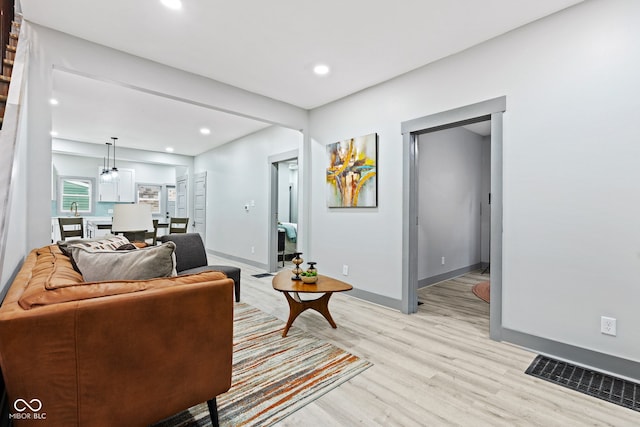 living room with light hardwood / wood-style floors and sink