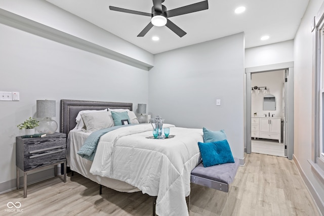 bedroom with ensuite bath, light hardwood / wood-style flooring, ceiling fan, and sink